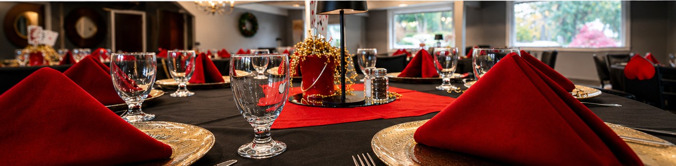 Dining room tables set with linens, stemware and gold chargers beside windows at Longview Country Club